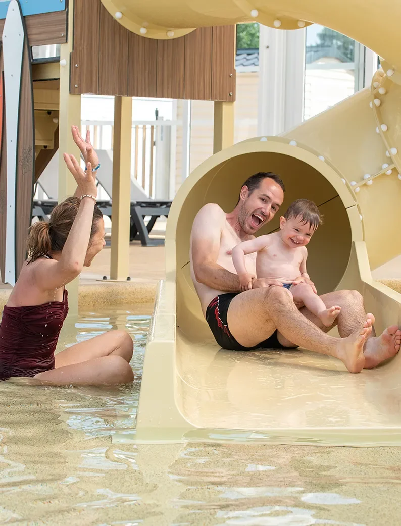 Famille profitant d’un toboggan aquatique pour enfant au Camping Club Pontaillac Plage 4 étoiles.