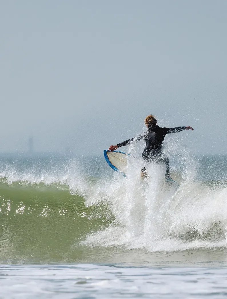 Surfeur effectuant une figure sur une vague à la Tranche-sur-Mer.