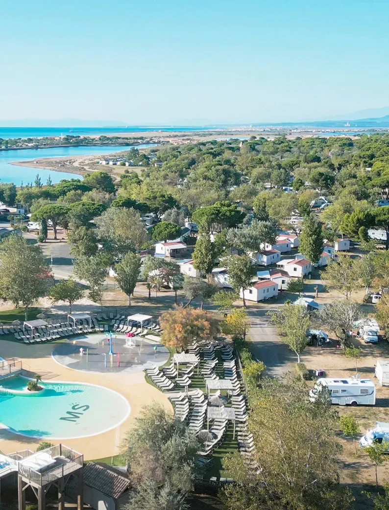 Vue aérienne du Camping Club La Côte des Roses 4 étoiles, en bord de mer et proposant des mobil-homes avec piscine.