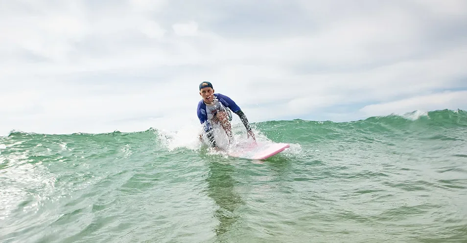 Surfeur sur une vague à la plage des Conches : surf proche du Camping Club Les Brunelles 5 étoiles.