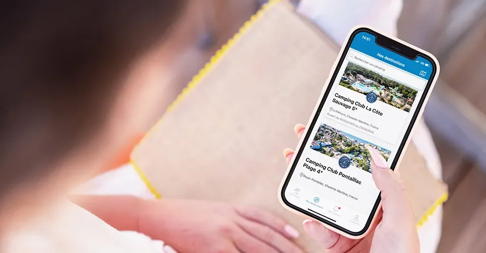 Femme consultant l'application MS Vacances pendant ses vacances en mobil-home.