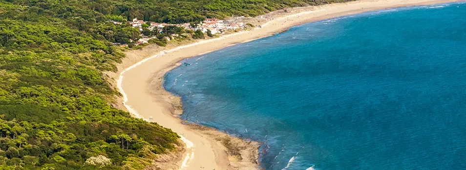 Plage sauvage vue du ciel près du Camping Club Les Brunelles 5 étoiles, proposant des mobil-homes avec piscine.