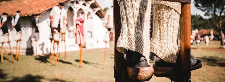 Gros plan sur des échasses traditionnelles en bois, portées par un participant lors d’une animation en plein air à l'Écomusée de Marquèze, dans les Landes.