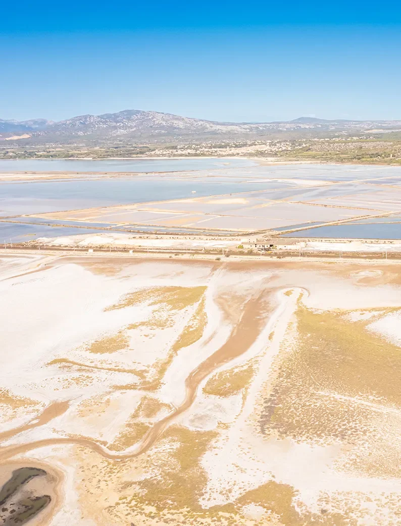 Vue aérienne des salins de la Palme, dans l'Aude, entre lagunes et montagnes.