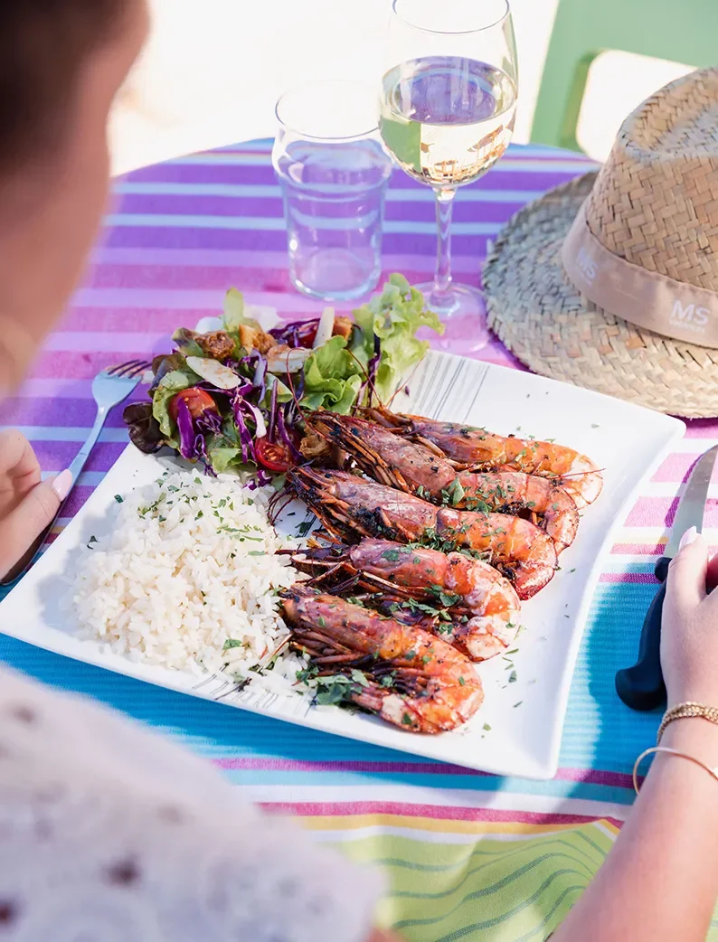 Plat de gambas grillées avec riz et salade, sur la terrasse du mobil-home avec piscine.