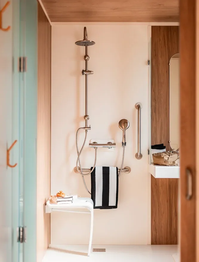 Salle de bain accessible avec douche PMR et barres d'appui dans un mobil-home MS Vacances.