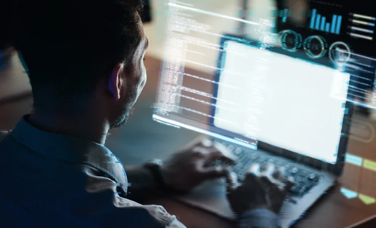 Man looking at a laptop with chart and code graphics overlaid