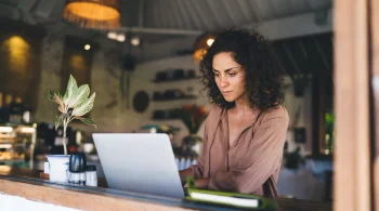 Woman focused on laptop in cozy cafe