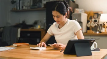 Woman doing calculations with a tablet in a cozy room