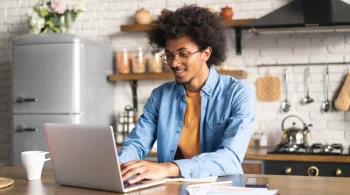 Man working on a laptop in a cozy kitchen setting