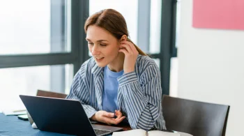 Woman using laptop, engaged in conversation