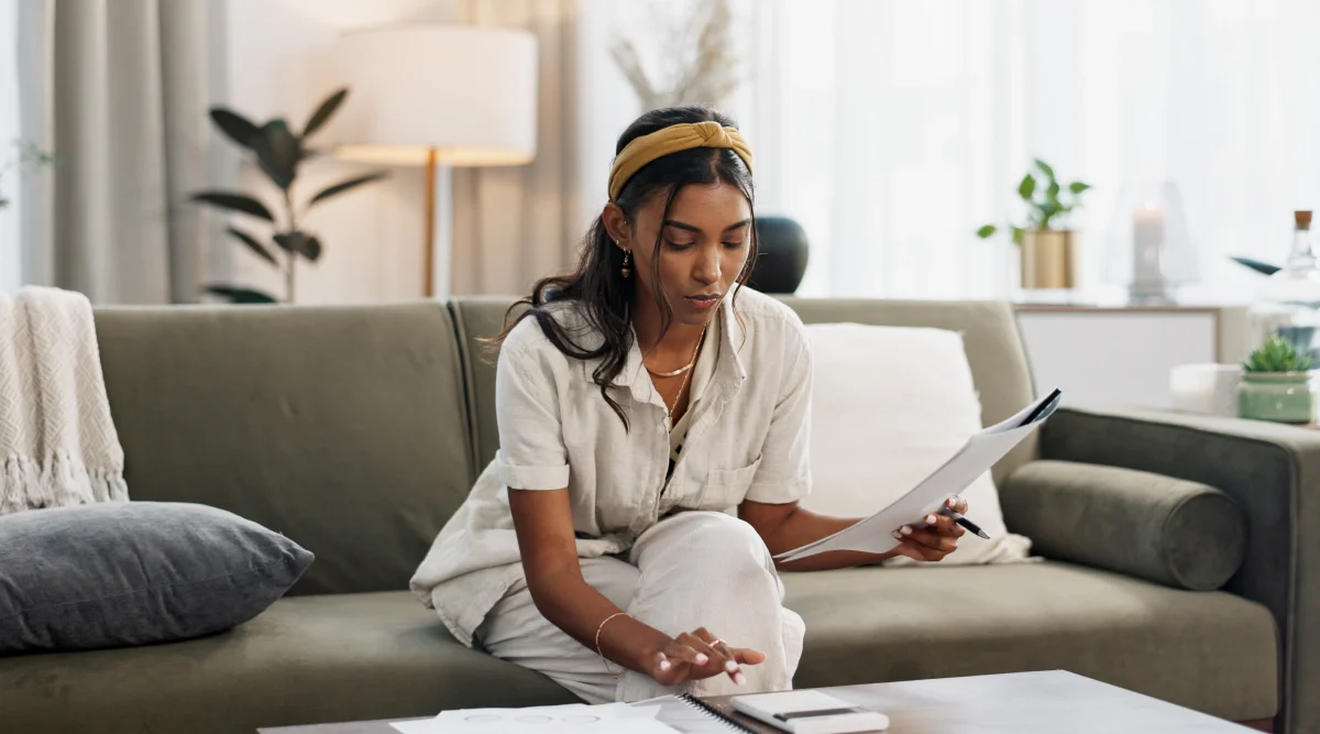 An image of a woman wearing glasses and smiling while preparing her will documents and deciding on the appointment of guardians to her children in her will.