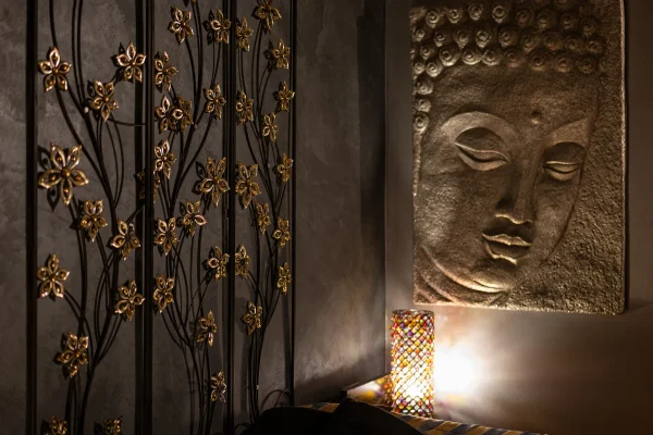 Wide-angle view of the Stimulos spa treatment room with massage table and candles
