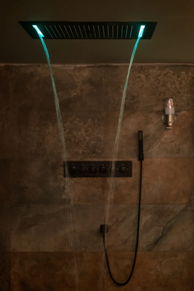 Rainfall shower with warm lighting inside the Stimulos private spa in Barcelona