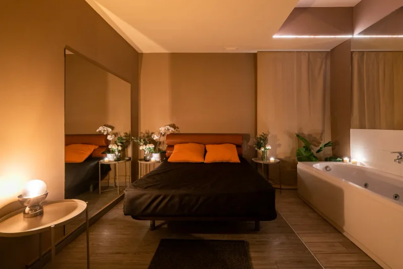Intimate treatment room with soft red lighting and luxury decor
