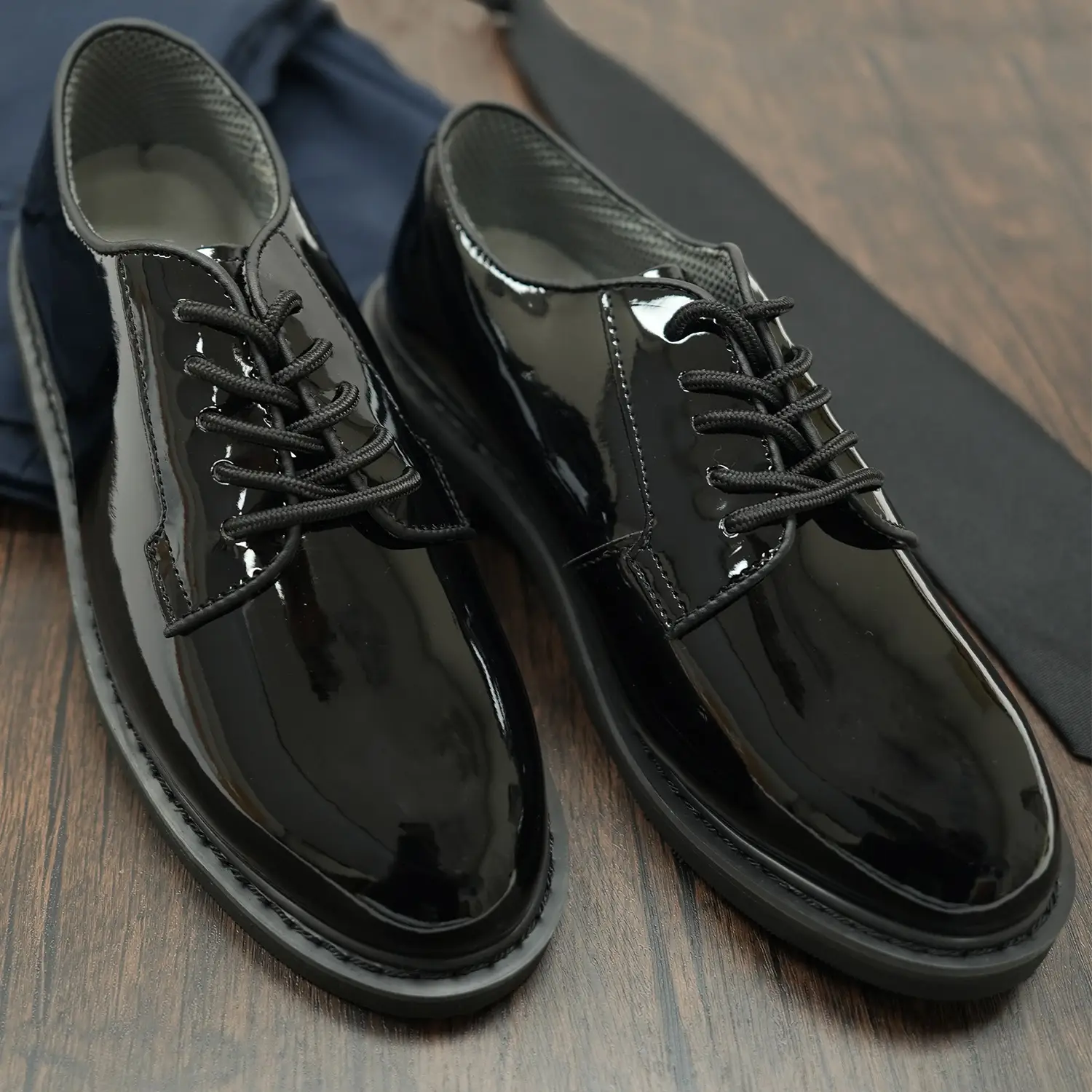 glossy black dress shoes on table