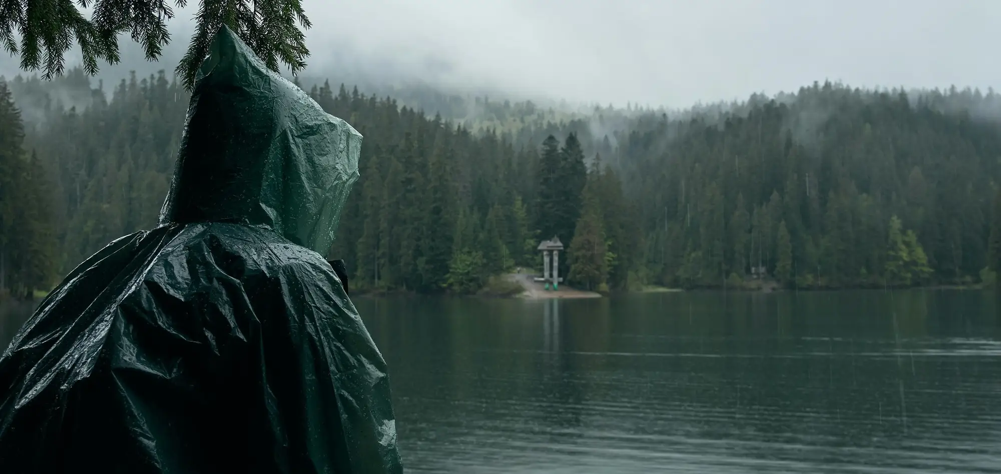 person wearing poncho outdoors by lake