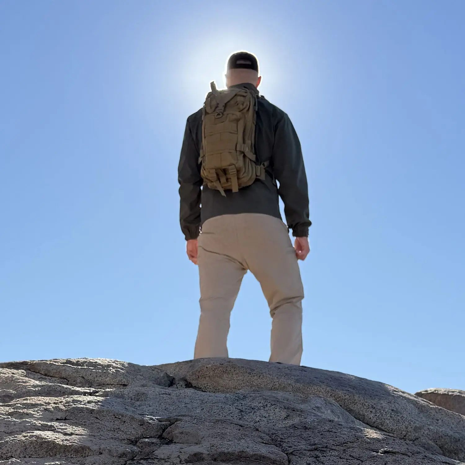 Man on mountain with Tactical Pack