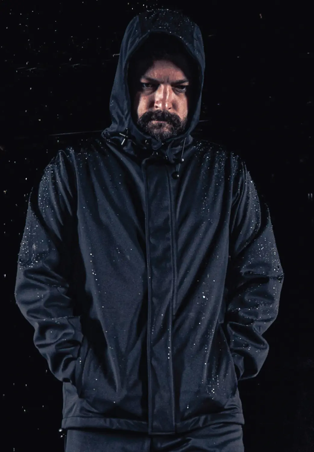 man wearing rain jacket in dark background