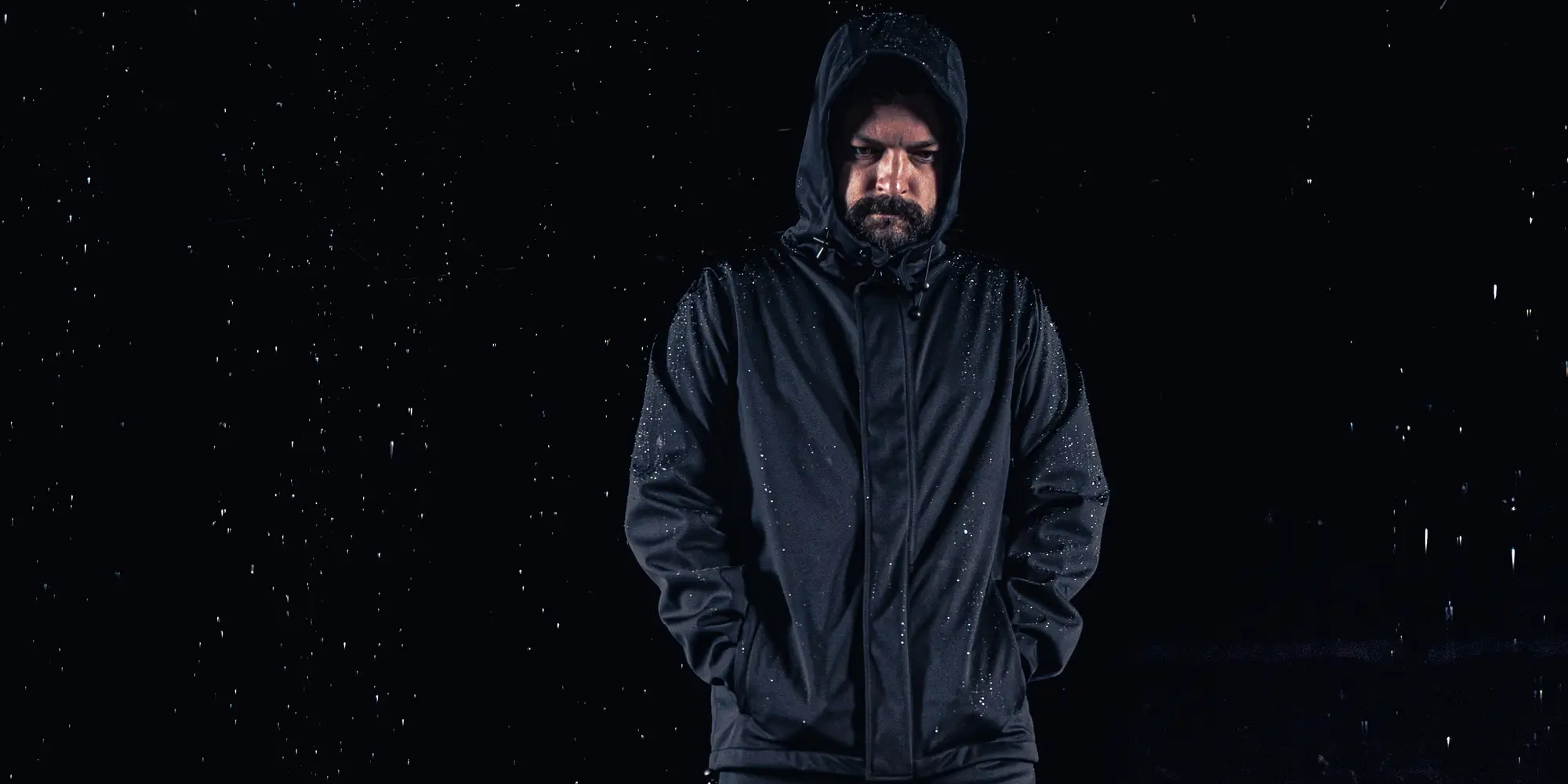 man wearing rain jacket in dark background