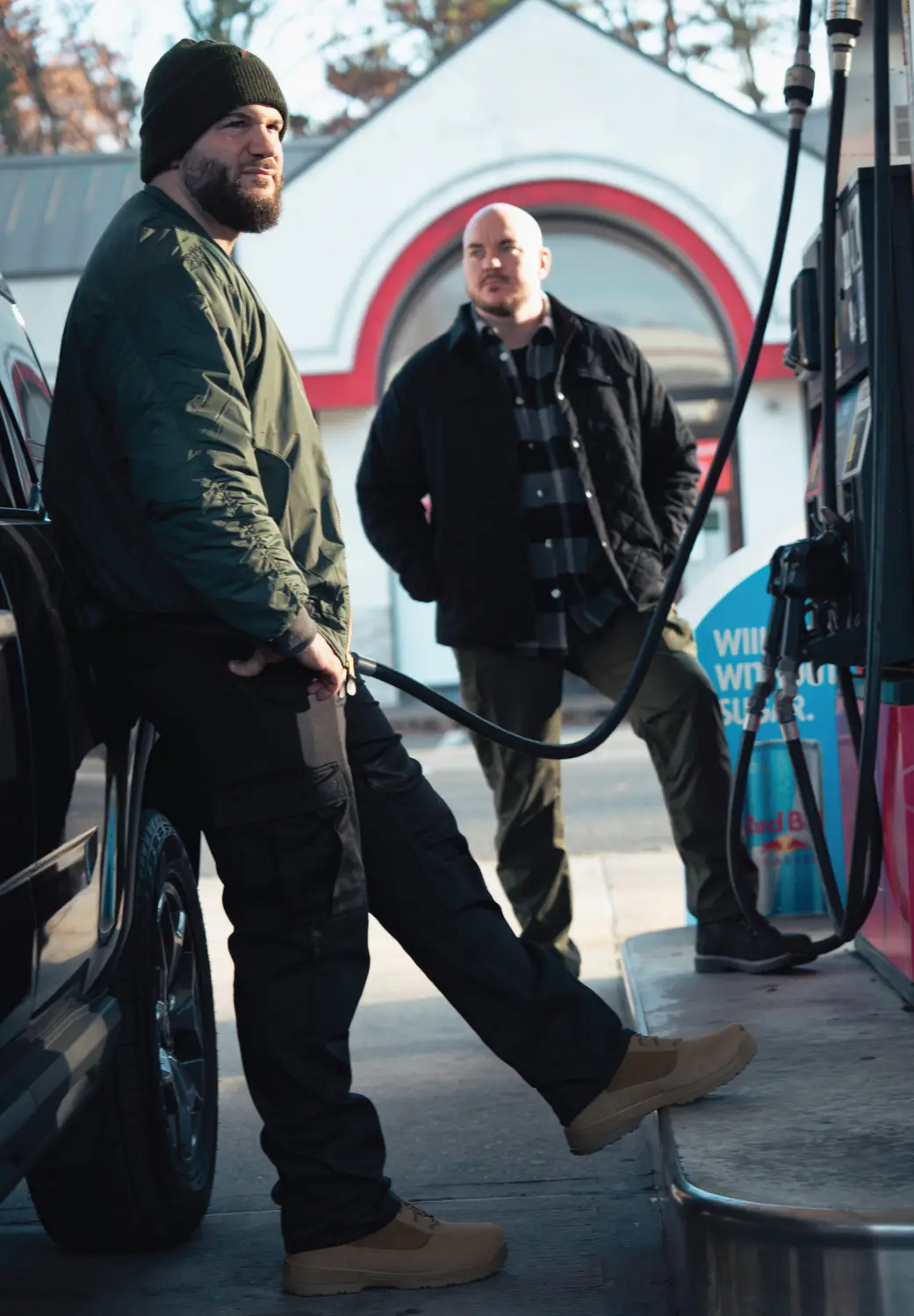 Two Men Wearing Casual Travel Jackets Sitting On Bench