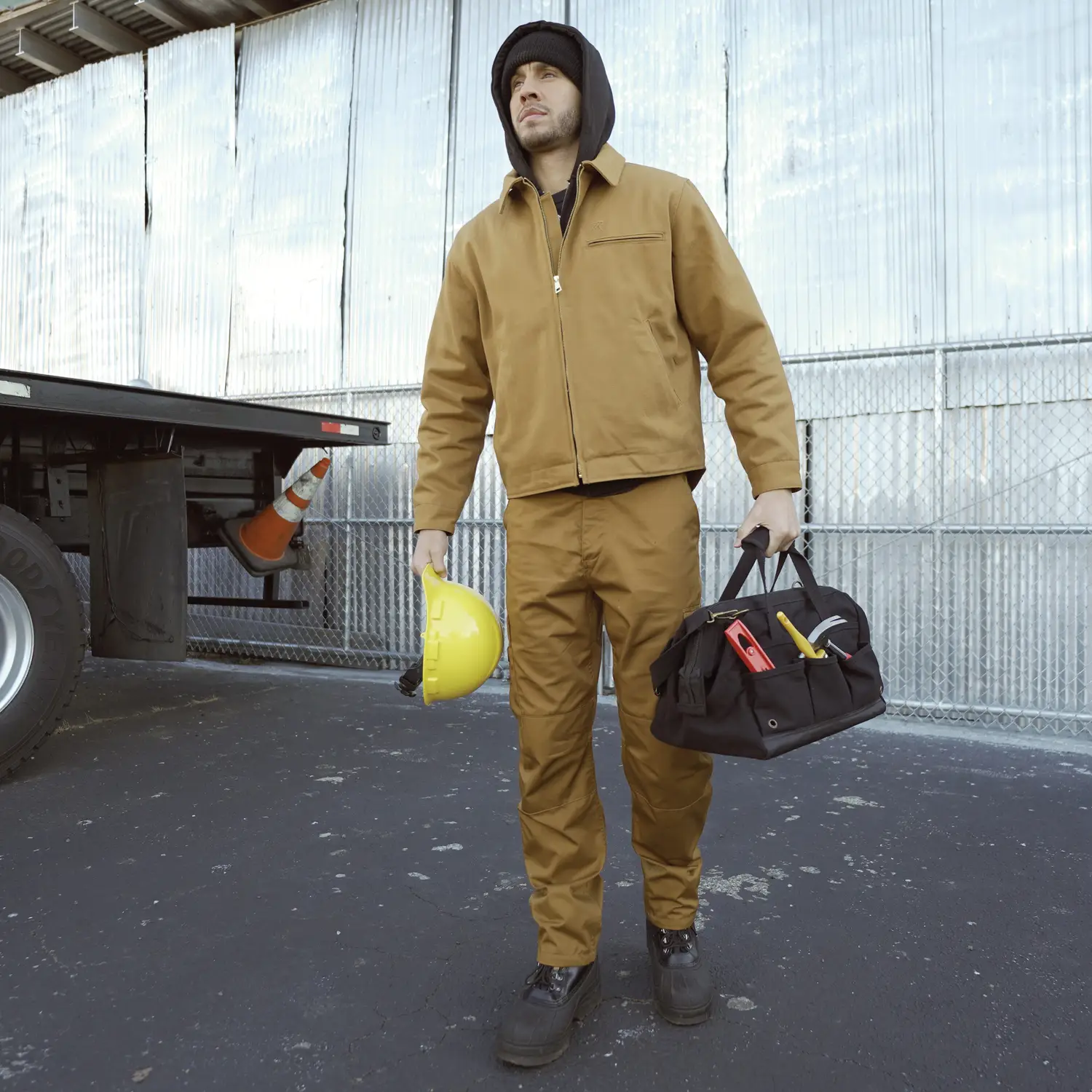 Man on a job site with a tool bag and construction attire