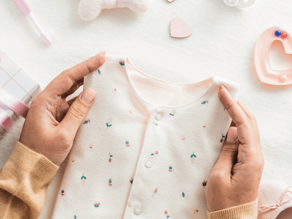 A woman holding a piece of child clothing.