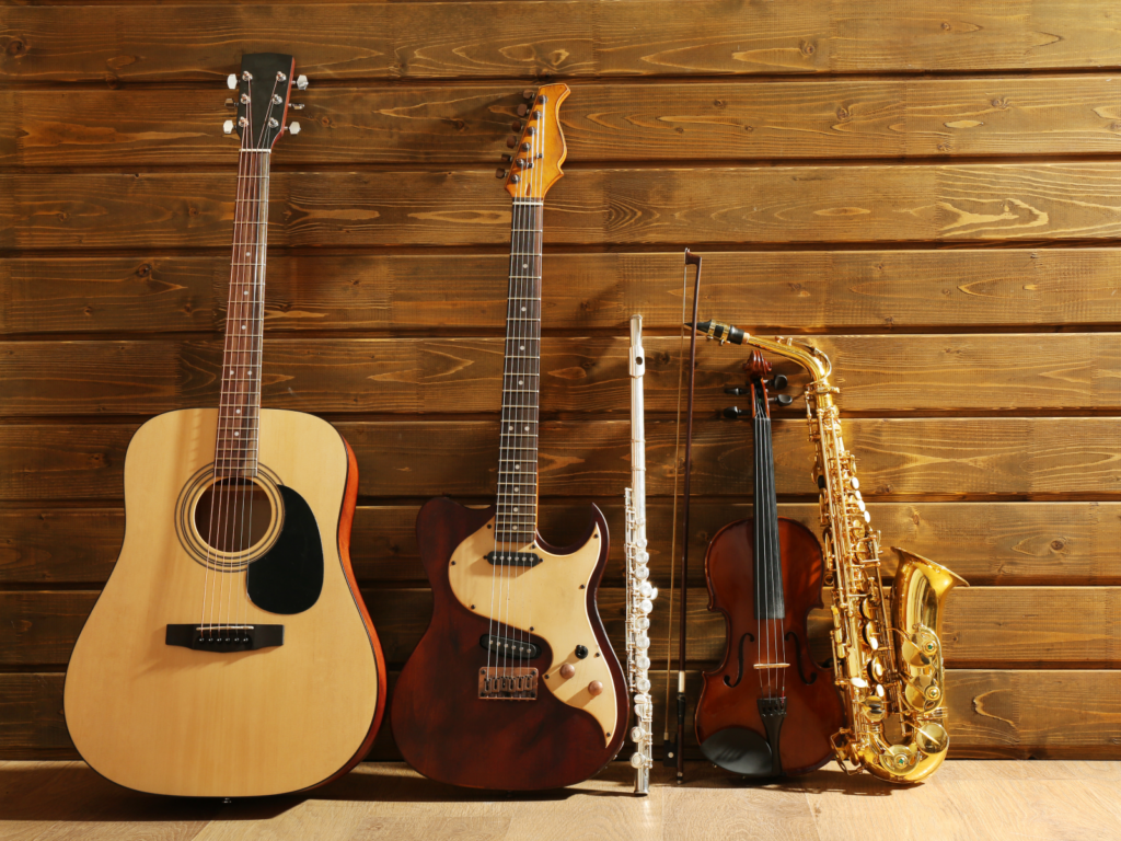 Guitars, a saxophone, and a violin arranged on a wooden wall, highlighting premium musical instruments for dropshipping.