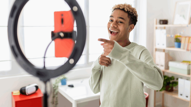 A social media influencer recording himself with a mobile phone.