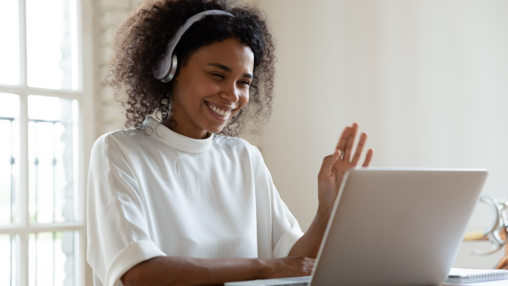 A woman wearing headphones, focused on her laptop, immersed in her work.