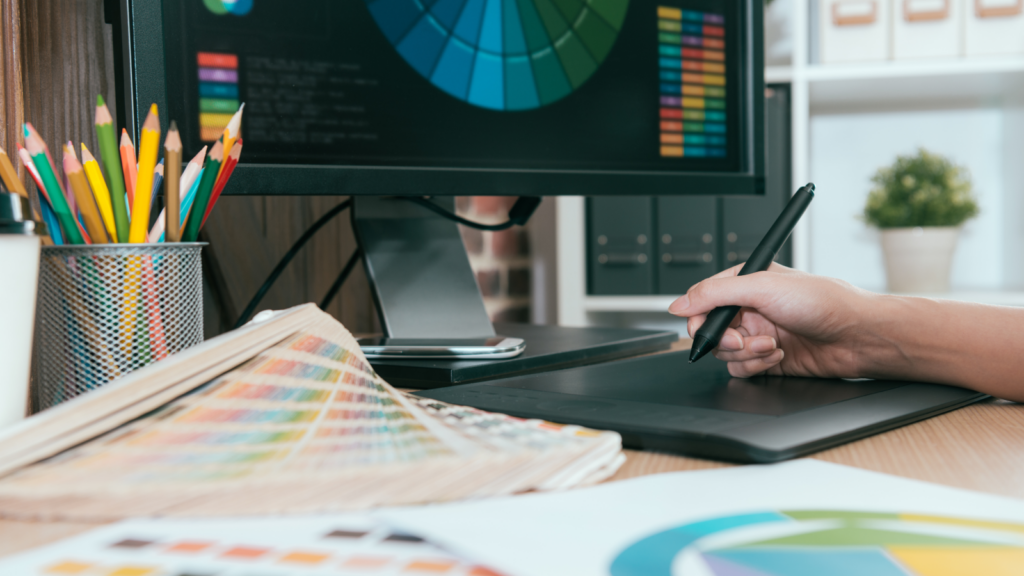 A graphic designer using a design pad to create graphic design elements.
