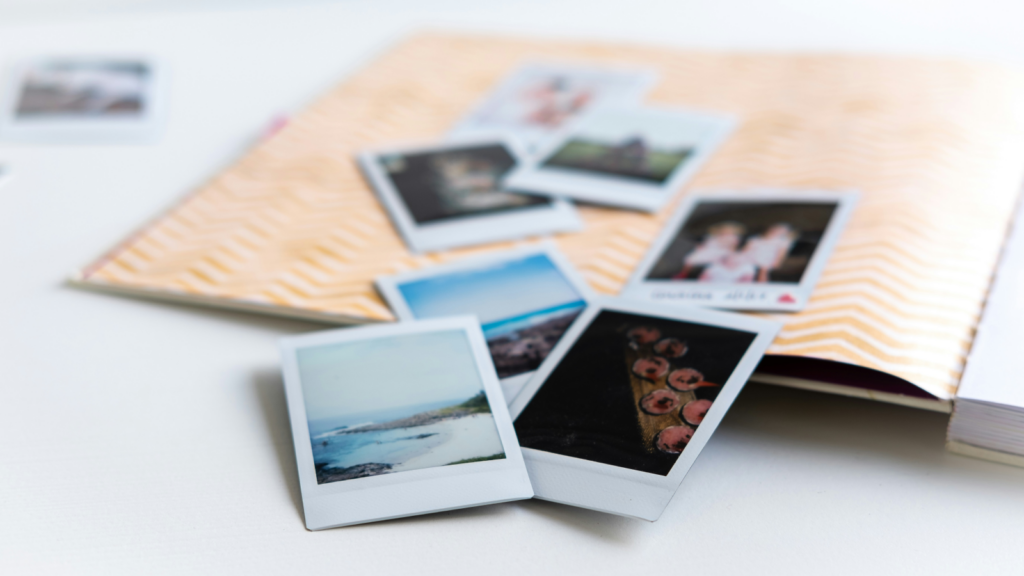 A photo book displaying various images alongside an open notebook, inviting reflection and creativity.