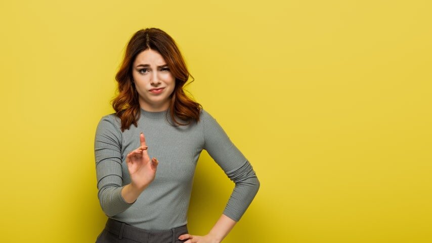 A woman looking at something and frowning.