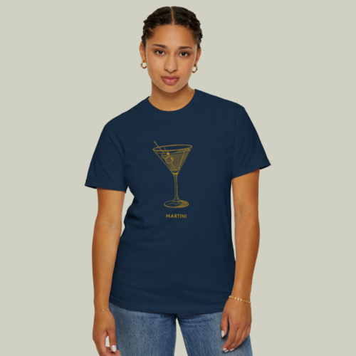 A woman wearing a blue and gold “Martini” t-shirt on a light olive green background.