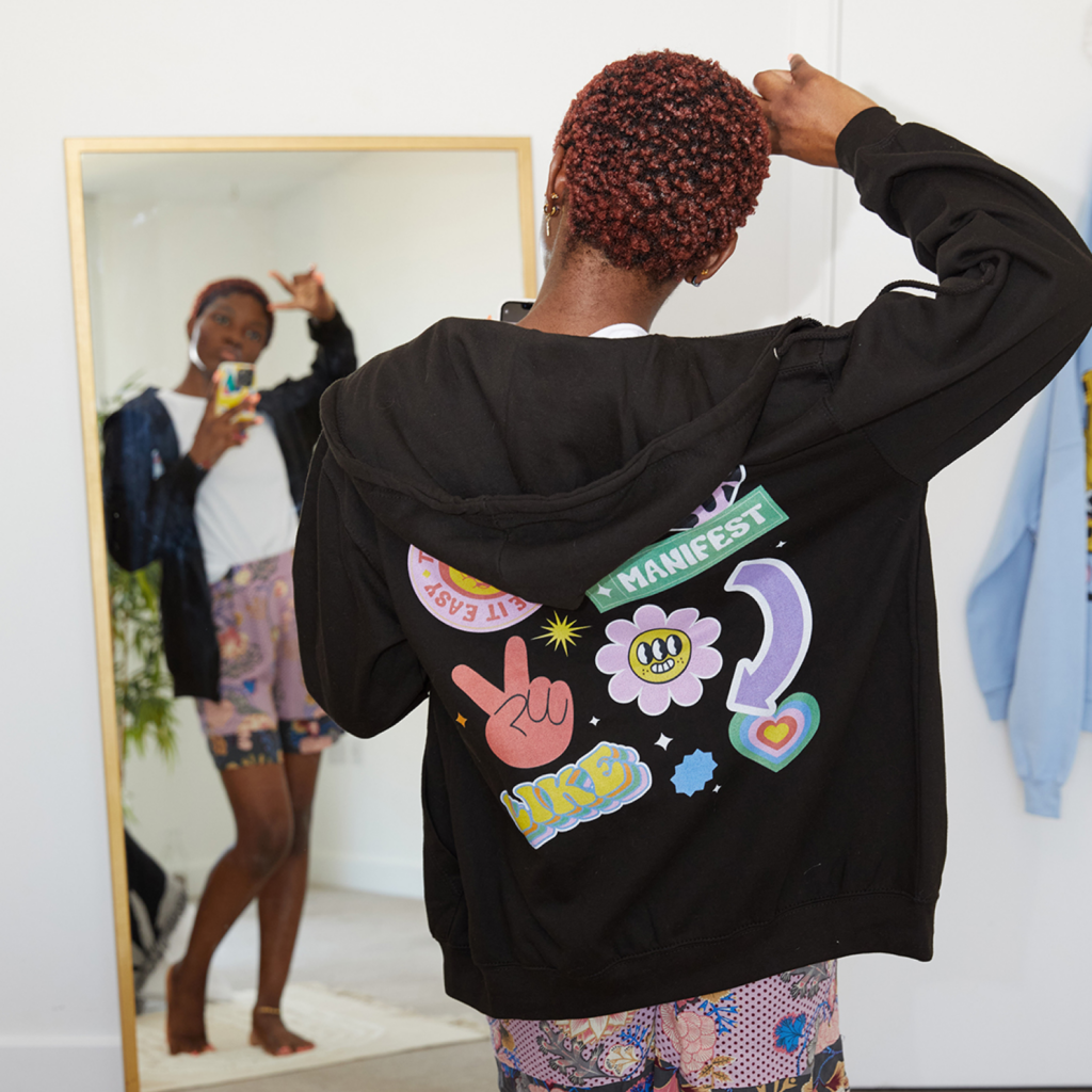 A woman wearing a custom black hoodie with a back print.
