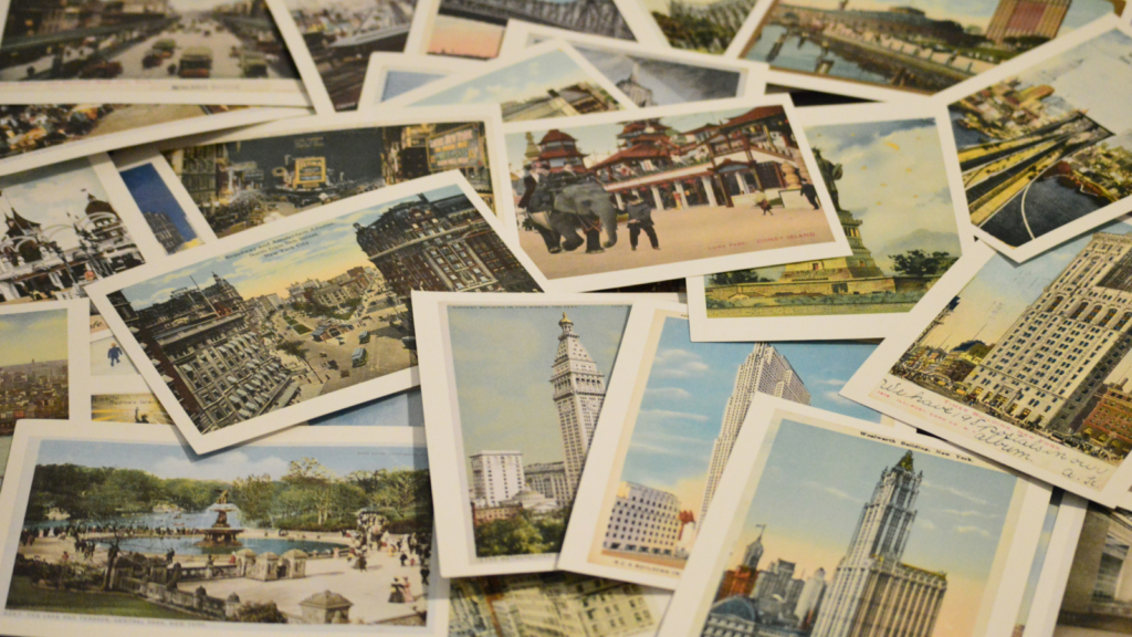 A collection of postcards featuring diverse buildings and landmarks stacked together in a colorful display.