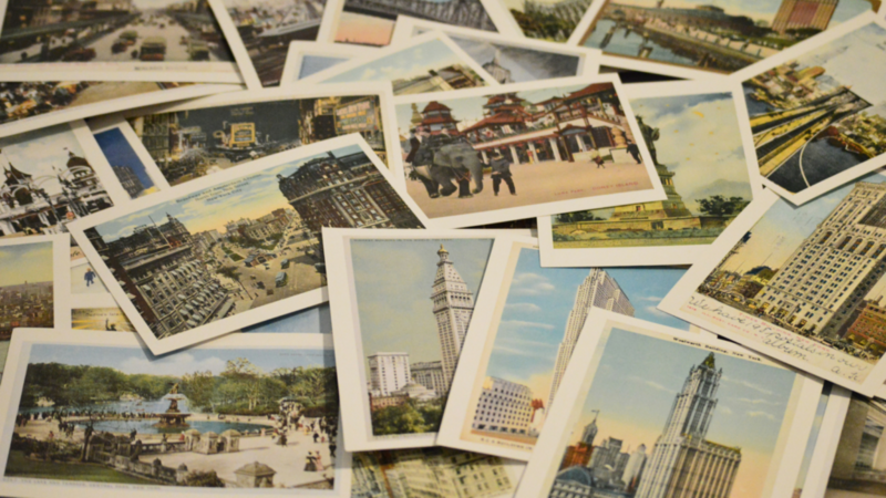 A collection of postcards featuring diverse buildings and landmarks stacked together in a colorful display.