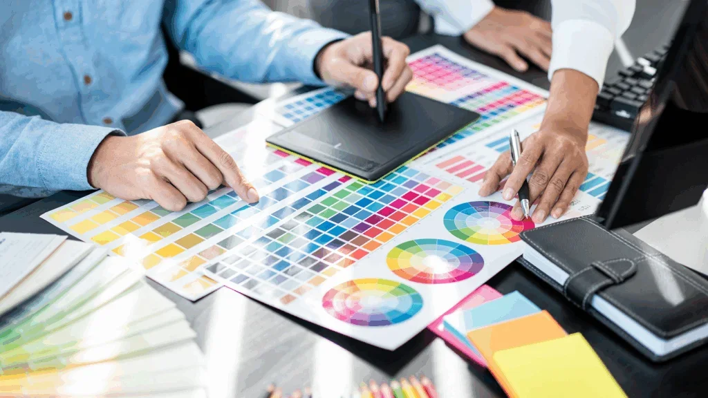 Two people are choosing a color from a color palette print-out