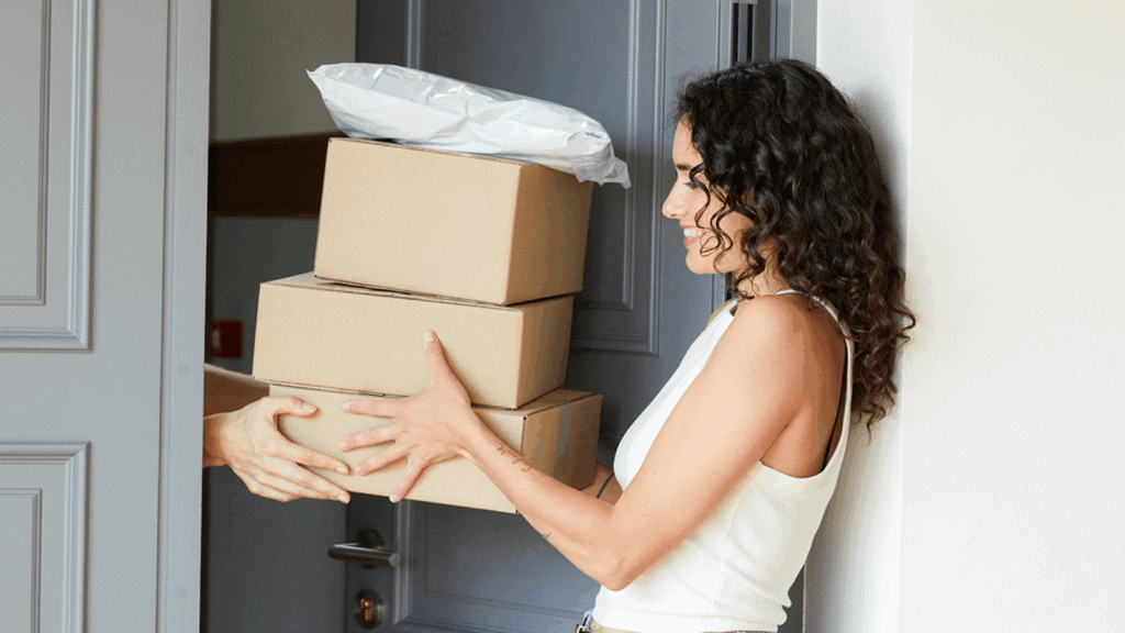 A woman and a man are both holding a box together, demonstrating teamwork and collaboration.