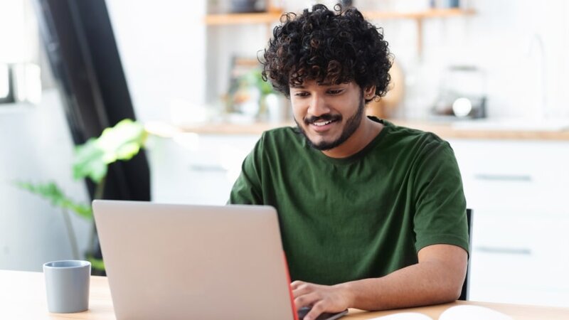 A man setting up his print-on-demand dropshipping business at his computer.