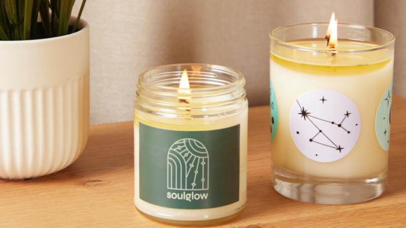 Candles: Two unique customized candles positioned beside a green plant.
