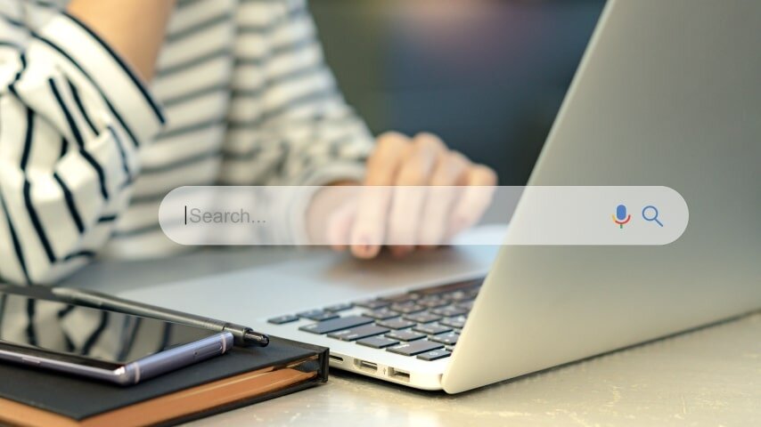 A woman using a laptop to perform keyword research. 
