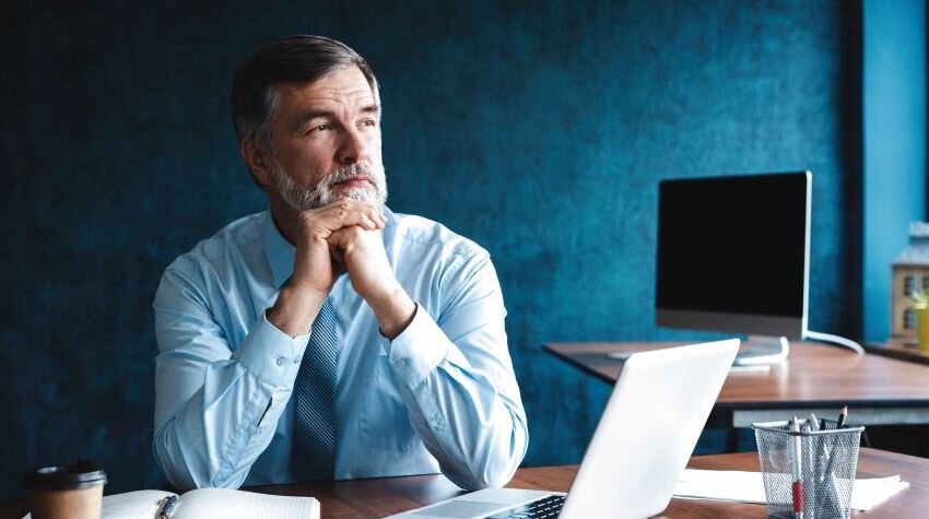 Concerned-looking man sitting at his desk.