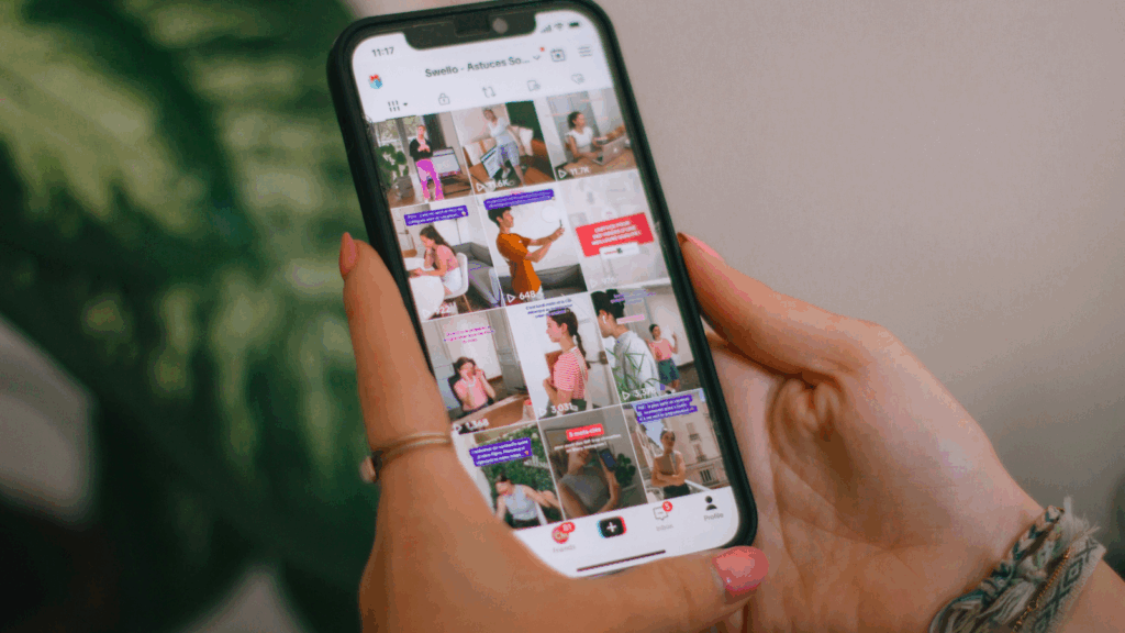 A woman is holding a mobile phone and scrolling through TikTok.