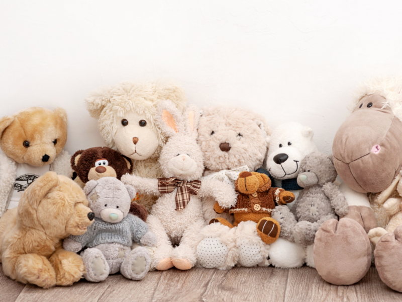 A collection of stuffed animals arranged on a wooden floor.