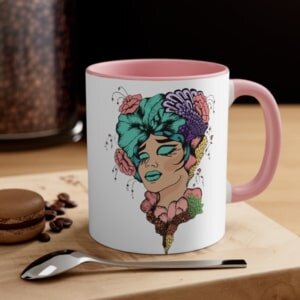 White mug with a pink inner accent and an illustration of a stylized woman with colorful flowers in her hair.