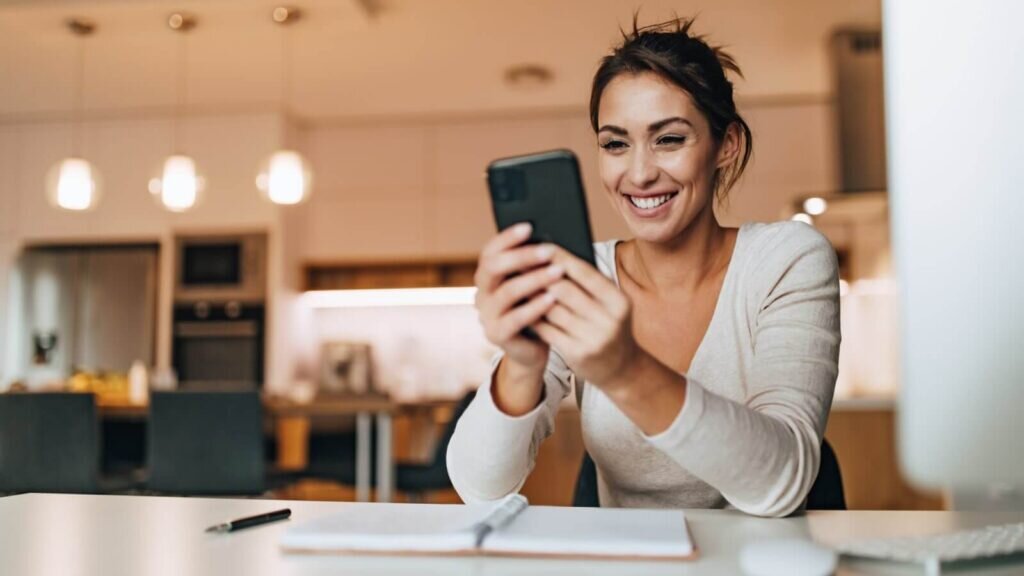 A woman learning what to sell on eBay in the UK on her phone.