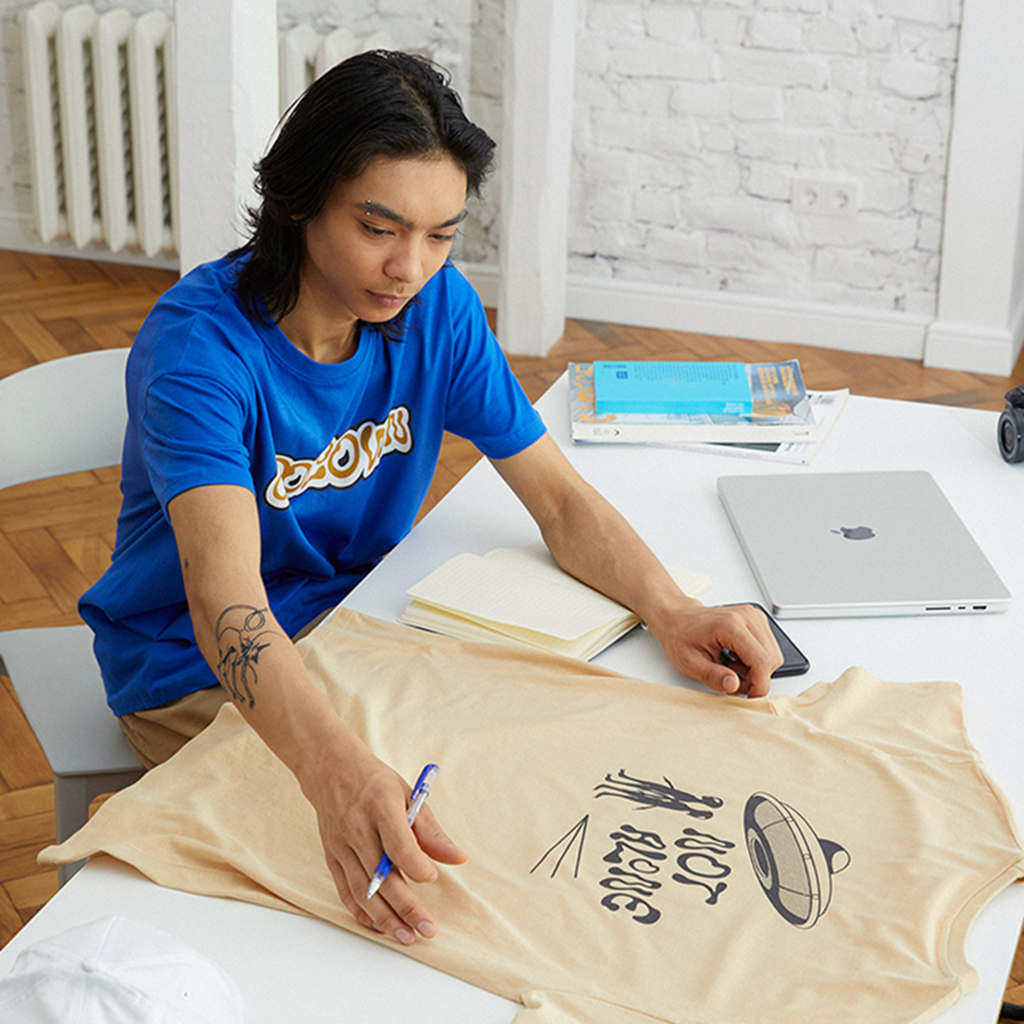 A small business owner is seated at a table, exploring and comparing DTF vs DTG printing.