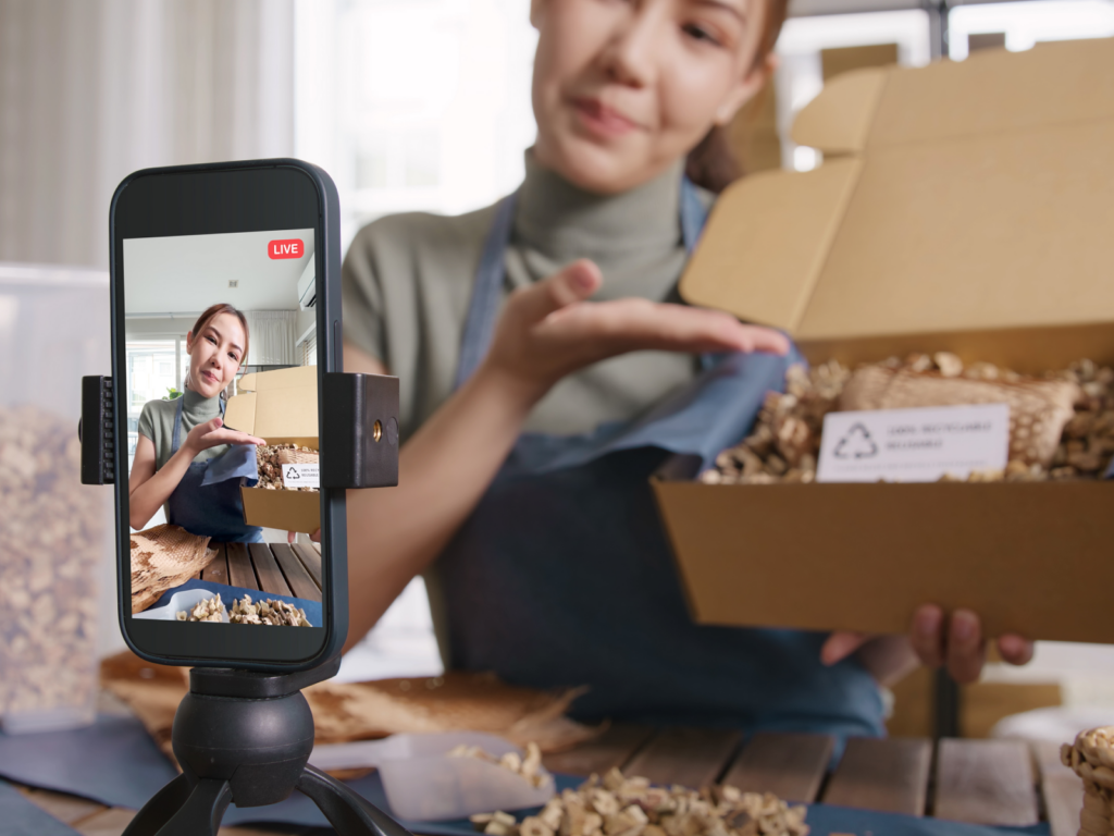 A woman using her phone's video camera to livestream, creating engaging and high-quality content for Instagram.
