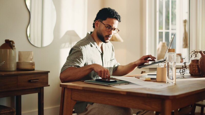 A family is seated on a couch, engaging with a laptop and managing an Etsy store together.